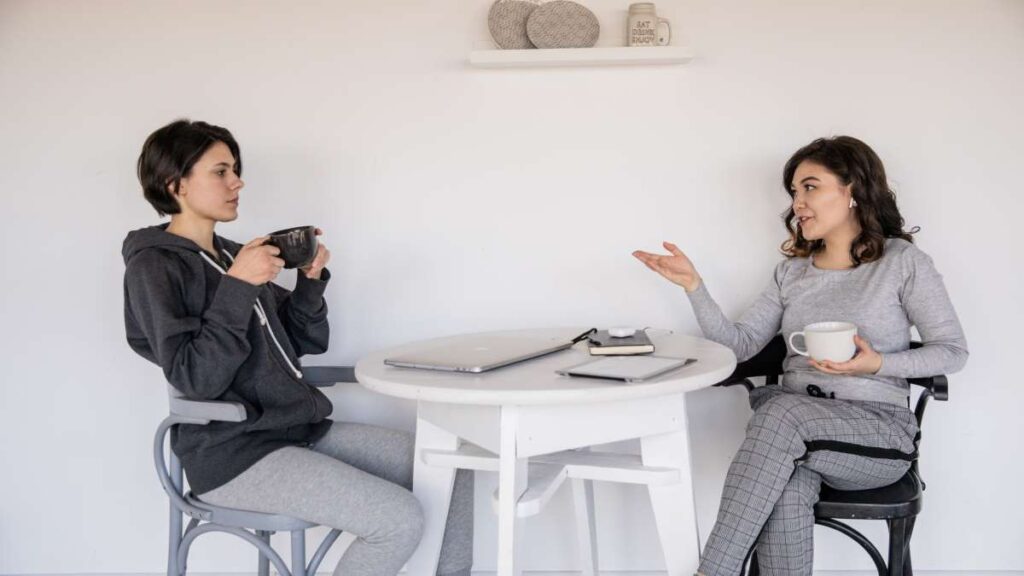コーヒーを飲みながら話をする二人の女性